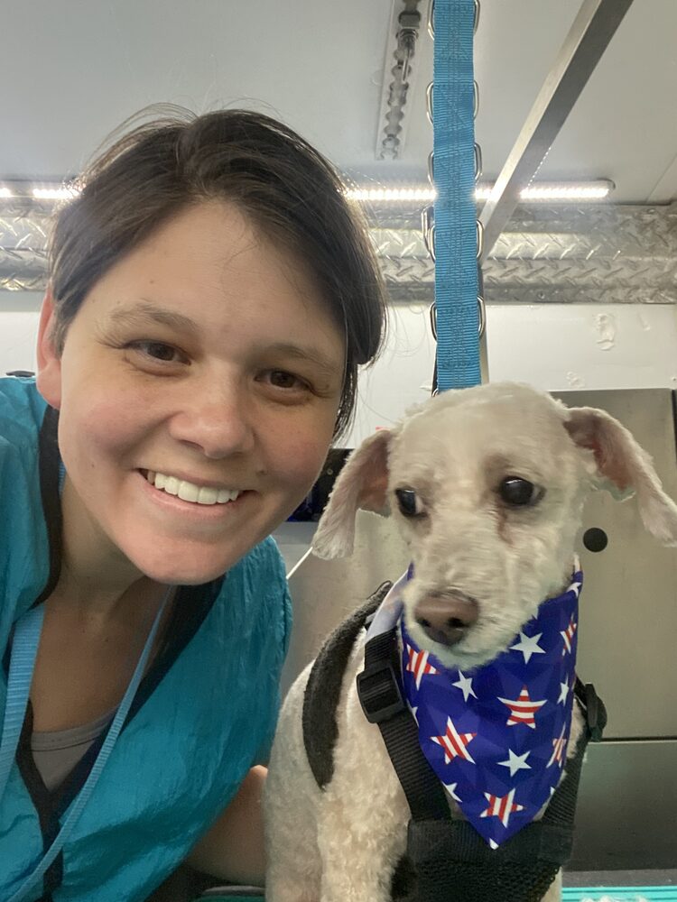 Amy, owner of Dashing Paws, with a freshly groomed client dog inside her mobile grooming van